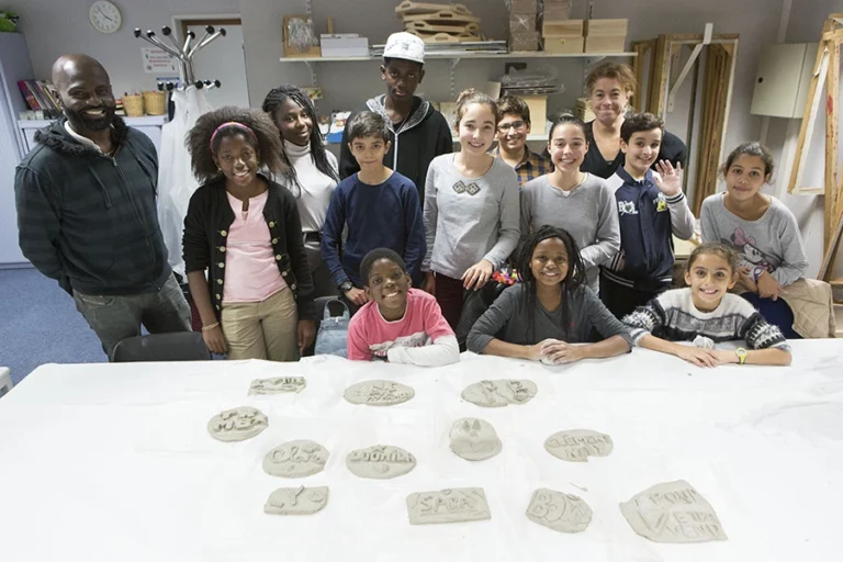 Illustration d'une photo de classe en poterie avec leurs réalisations Espace Jules Verne